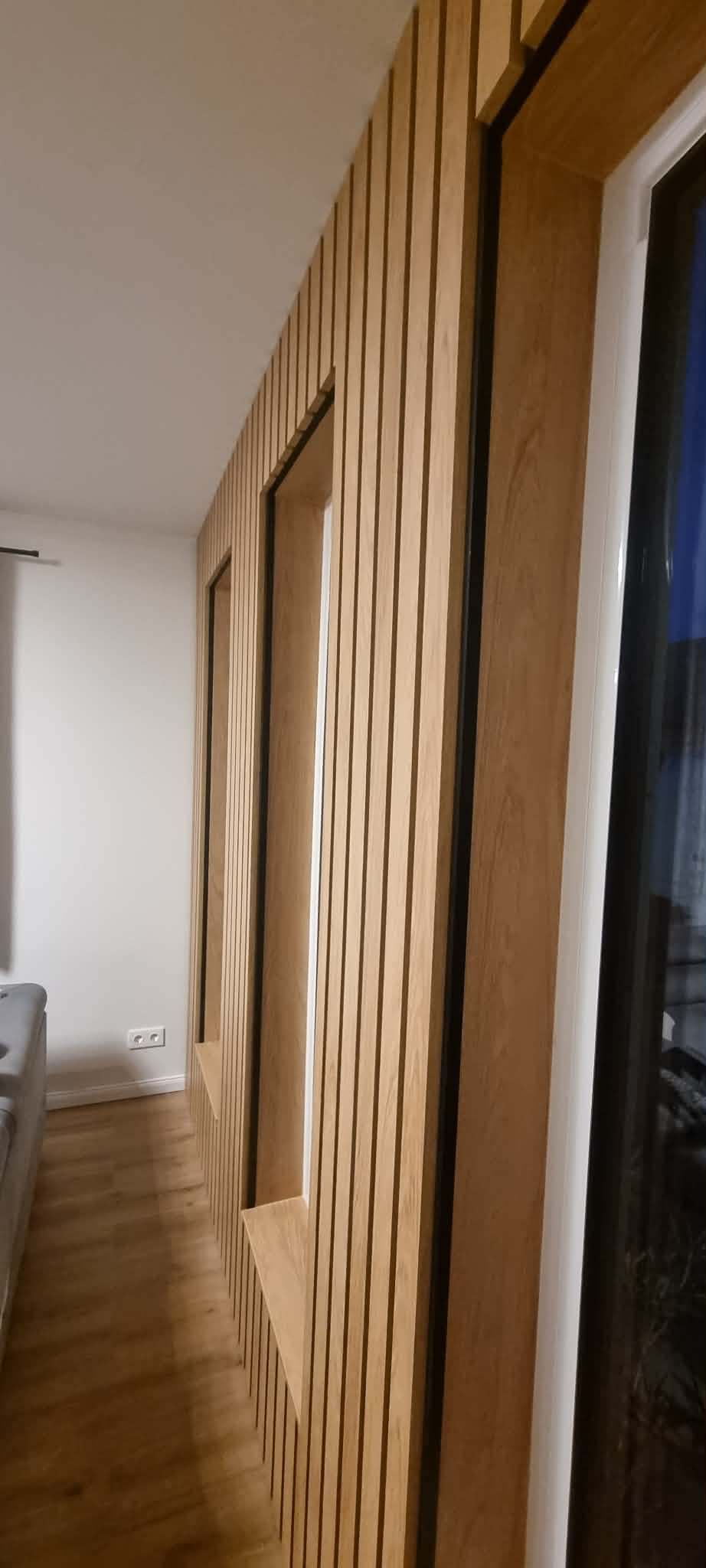 Padlótól mennyezetig érő lamellás tölgyfal beépített fülkékkel